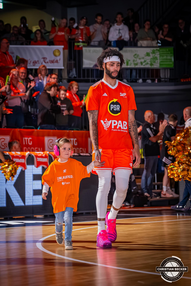 1. Basketball Bundesliga, easyCredit BBL, Saison 2025/2026, Herren, Hauptrunde, 5. Spieltag, 25.10.2025, RASTA Vechta - Telekom Baskets Bonn
Tevin Brown (#10 - RASTA Vechta) und die Einlaufkinder vor der Partie
Schlüsselwörter: 1. Bundesliga;25.10.2025;5. Spieltag;BBL;Basketball;Baskets;Bonn;Hauptrunde;Liga;RASTA;RASTA Dome;Saison 2025/2026;Telekom;Vechta;easycredit