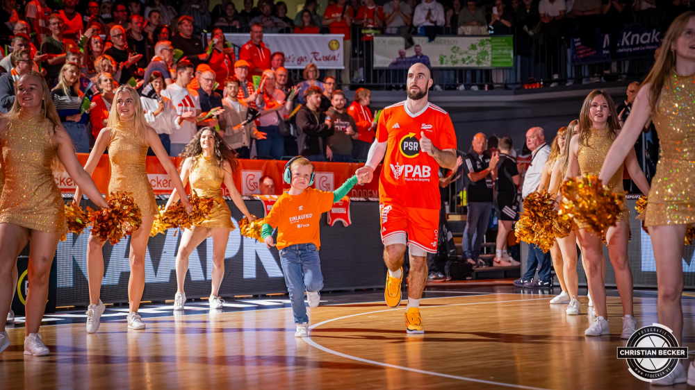 1. Basketball Bundesliga, easyCredit BBL, Saison 2025/2026, Herren, Hauptrunde, 5. Spieltag, 25.10.2025, RASTA Vechta - Telekom Baskets Bonn
Tommy Kuhse (#12 - RASTA Vechta) und die Einlaufkinder vor der Partie
Schlüsselwörter: 1. Bundesliga;25.10.2025;5. Spieltag;BBL;Basketball;Baskets;Bonn;Hauptrunde;Liga;RASTA;RASTA Dome;Saison 2025/2026;Telekom;Vechta;easycredit