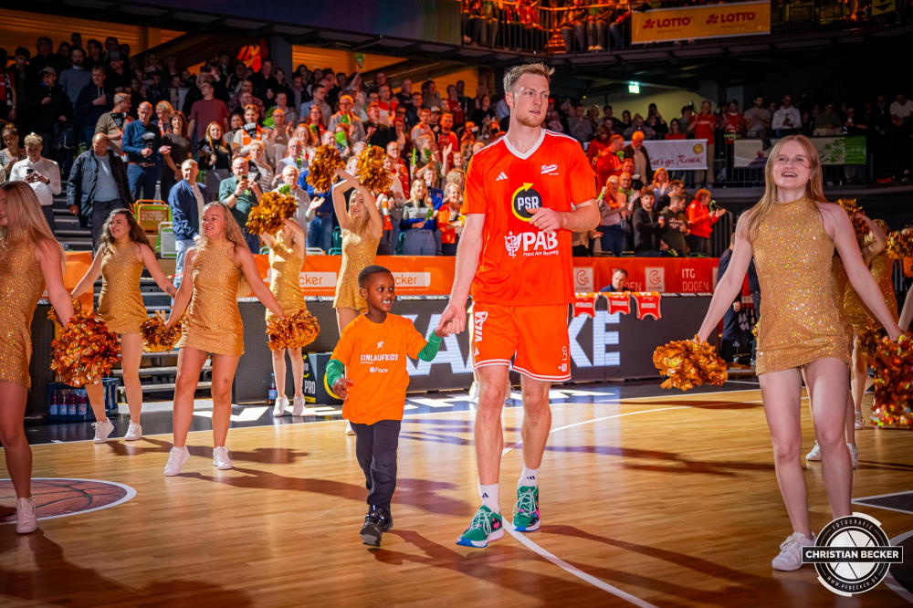 1. Basketball Bundesliga, easyCredit BBL, Saison 2025/2026, Herren, Hauptrunde, 5. Spieltag, 25.10.2025, RASTA Vechta - Telekom Baskets Bonn
Lars Thiemann (#21 - RASTA Vechta) und die Einlaufkinder vor der Partie
Schlüsselwörter: 1. Bundesliga;25.10.2025;5. Spieltag;BBL;Basketball;Baskets;Bonn;Hauptrunde;Liga;RASTA;RASTA Dome;Saison 2025/2026;Telekom;Vechta;easycredit