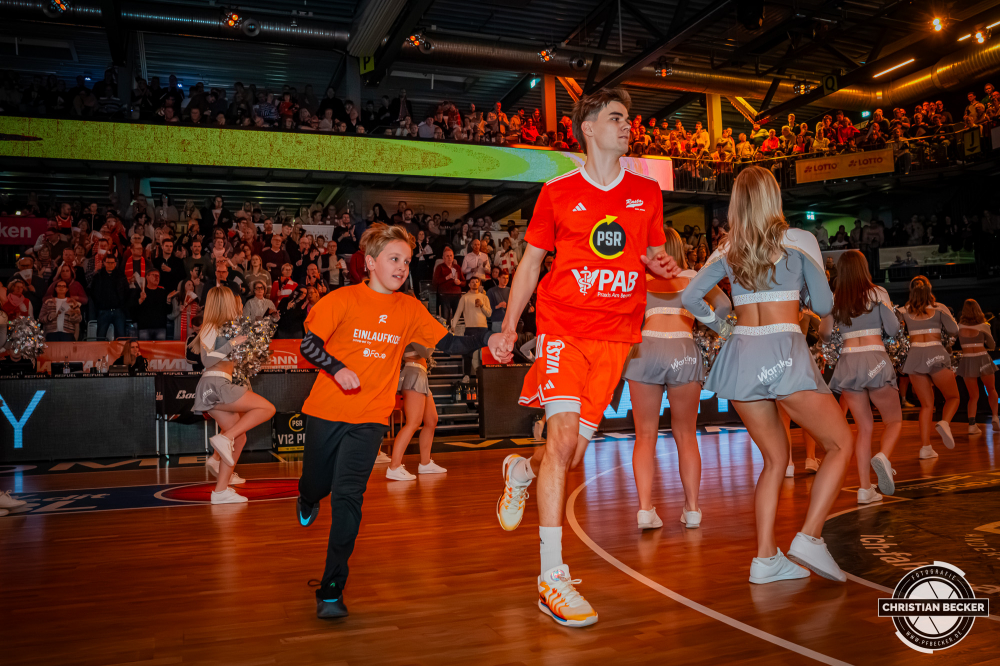 1. Basketball Bundesliga, easyCredit BBL, Saison 2025/2026, Herren, Hauptrunde, 15. Spieltag, 11.01.2026, RASTA Vechta - Fitness First W&uuml;rzburg Baskets
Joschka Ferner (#9 - RASTA Vechta) und ein Einlaufkind vor der Partie
Schlüsselwörter: 1. Bundesliga;11.01.2026;15. Spieltag;BBL;Basketball;Baskets;First;Fitness;Hauptrunde;Liga;RASTA;RASTA Dome;Saison 2025/2026;Vechta;W&uuml;rzburg;easycredit