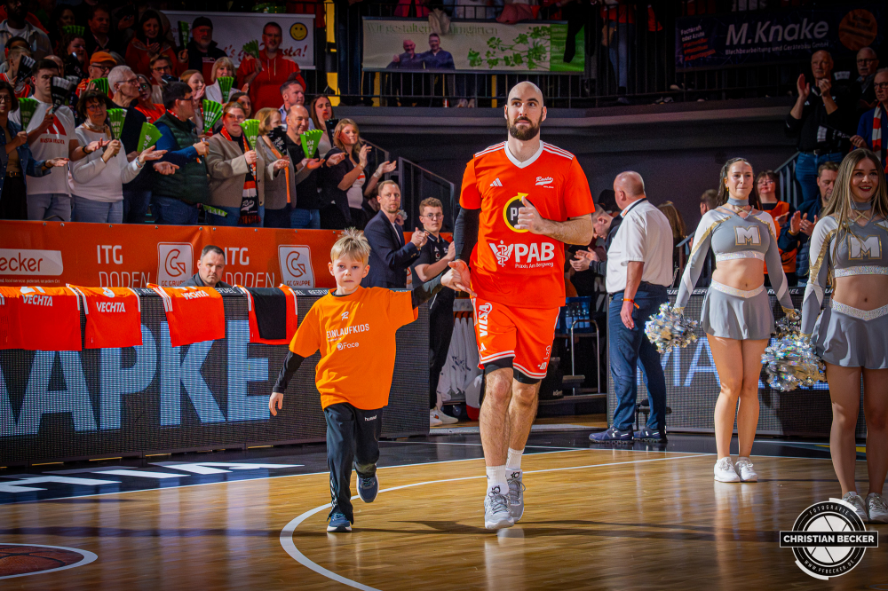 1. Basketball Bundesliga, easyCredit BBL, Saison 2025/2026, Herren, Hauptrunde, 25. Spieltag, 21.03.2026, RASTA Vechta - NINERS Chemnitz
Tommy Kuhse (#12 - RASTA Vechta) und ein Einlaufkind vor der Partie
Schlüsselwörter: 1. Bundesliga;21.03.2026;25. Spieltag;BBL;Basketball;Chemnitz;Hauptrunde;Liga;NINERS;RASTA;RASTA Dome;Saison 2025/2026;Vechta;easycredit