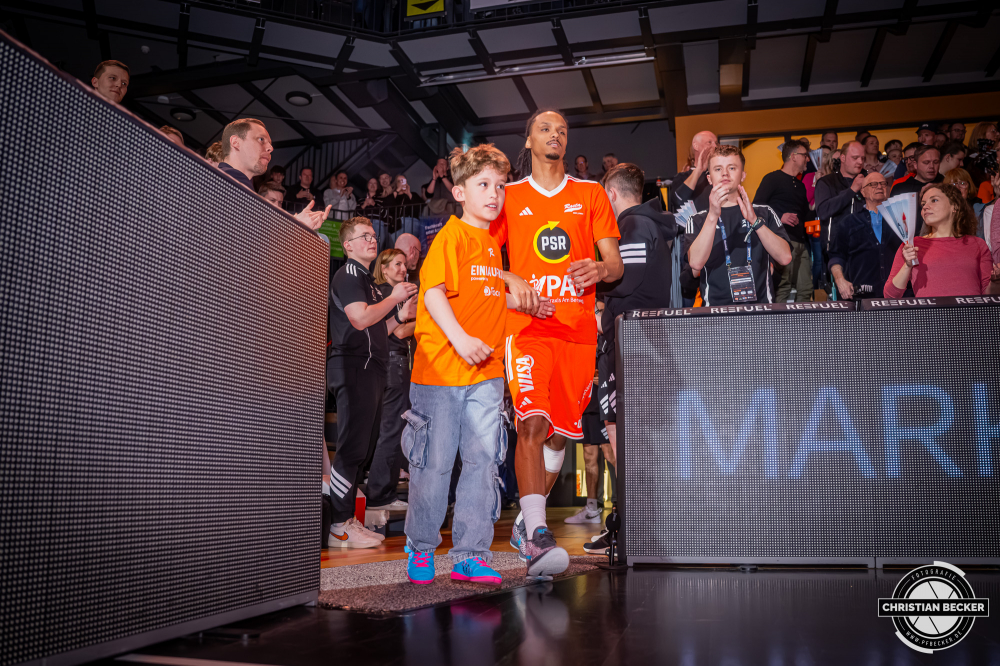 1. Basketball Bundesliga, easyCredit BBL, Saison 2025/2026, Herren, Hauptrunde, 29. Spieltag, 11.04.2026, RASTA Vechta - Gladiators Trier
Alonzo Verge (#11 - RASTA Vechta) und ein Einlaufkind vor der Partie
Schlüsselwörter: 1. Bundesliga;11.04.2026;29. Spieltag;BBL;Basketball;Gladiators;Hauptrunde;Liga;RASTA;RASTA Dome;Saison 2025/2026;Trier;VET-CONCEPT;Vechta;easycredit